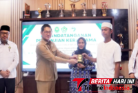 Wlikota Bitung Hengky Honandar, S.E, saat menyerahkan Buku Nikah kepada Pasutri di dampingi Kakan Kemenag Bitung, H. Yahya W. Pasiak, S.Ag., M.M (Ft. Ist)