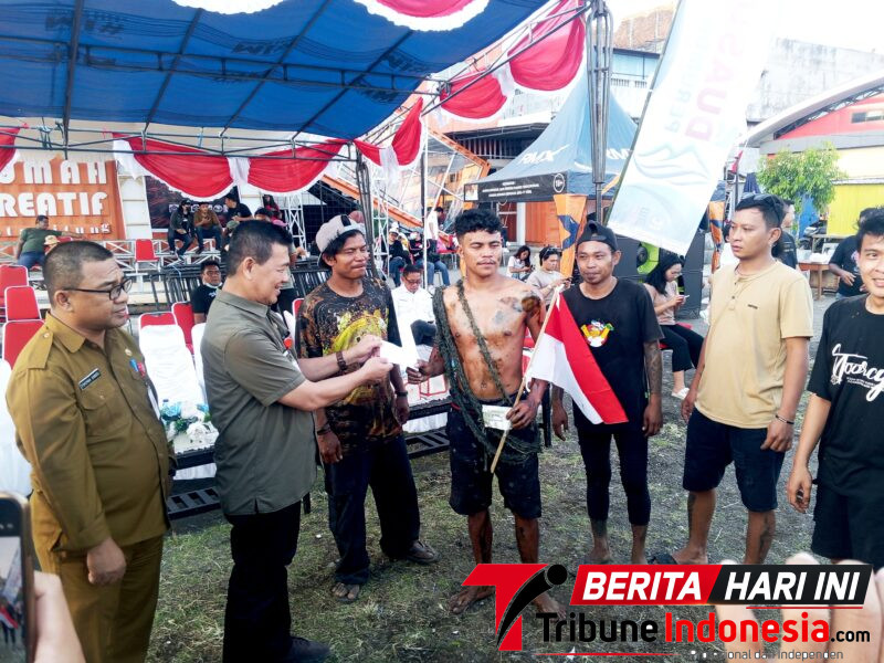 ‎Plt Asisten II Perekonomian dan Pembangunan Setda Kota Bitung, Michael Sondakh, S.Sos., MAP., Saat menyerahkan Hadiah. (Ft. talia)